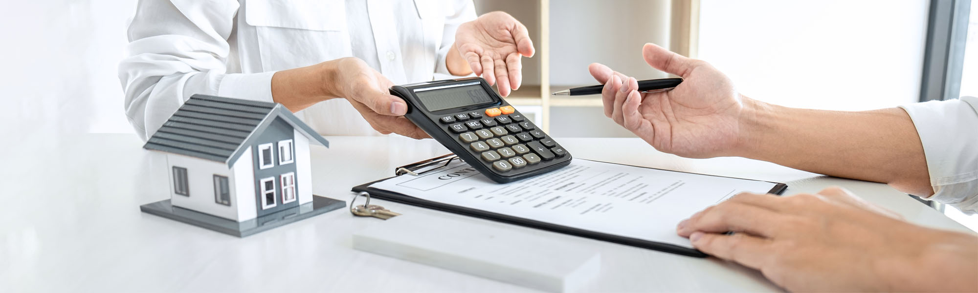 2 people conducting rental rate negotiations at a desk while looking at a calculator and legal documents - NYC Lease Dispute Lawyer concept image