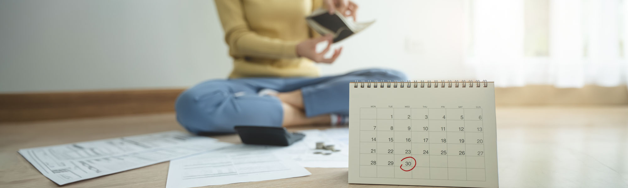 stressed person sitting on the floor opening empty wallet