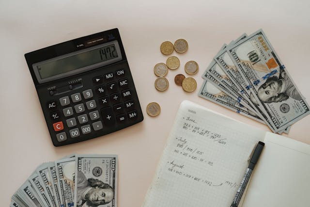 a calculator and a pile of money