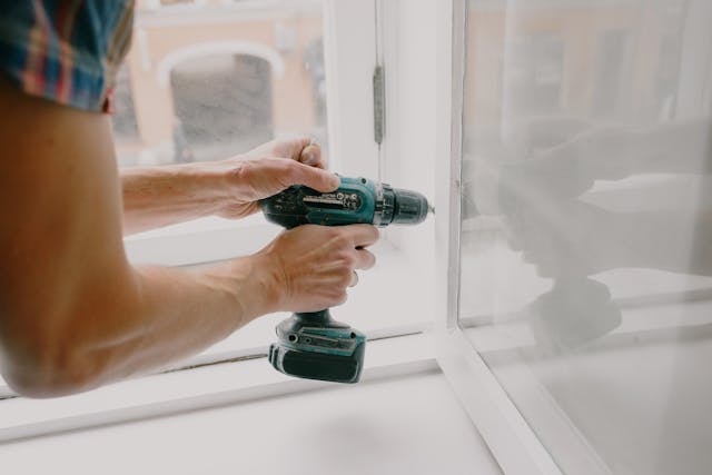 person using power drill to make repairs