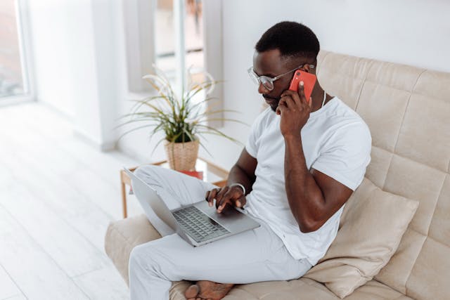 man using phone and laptop